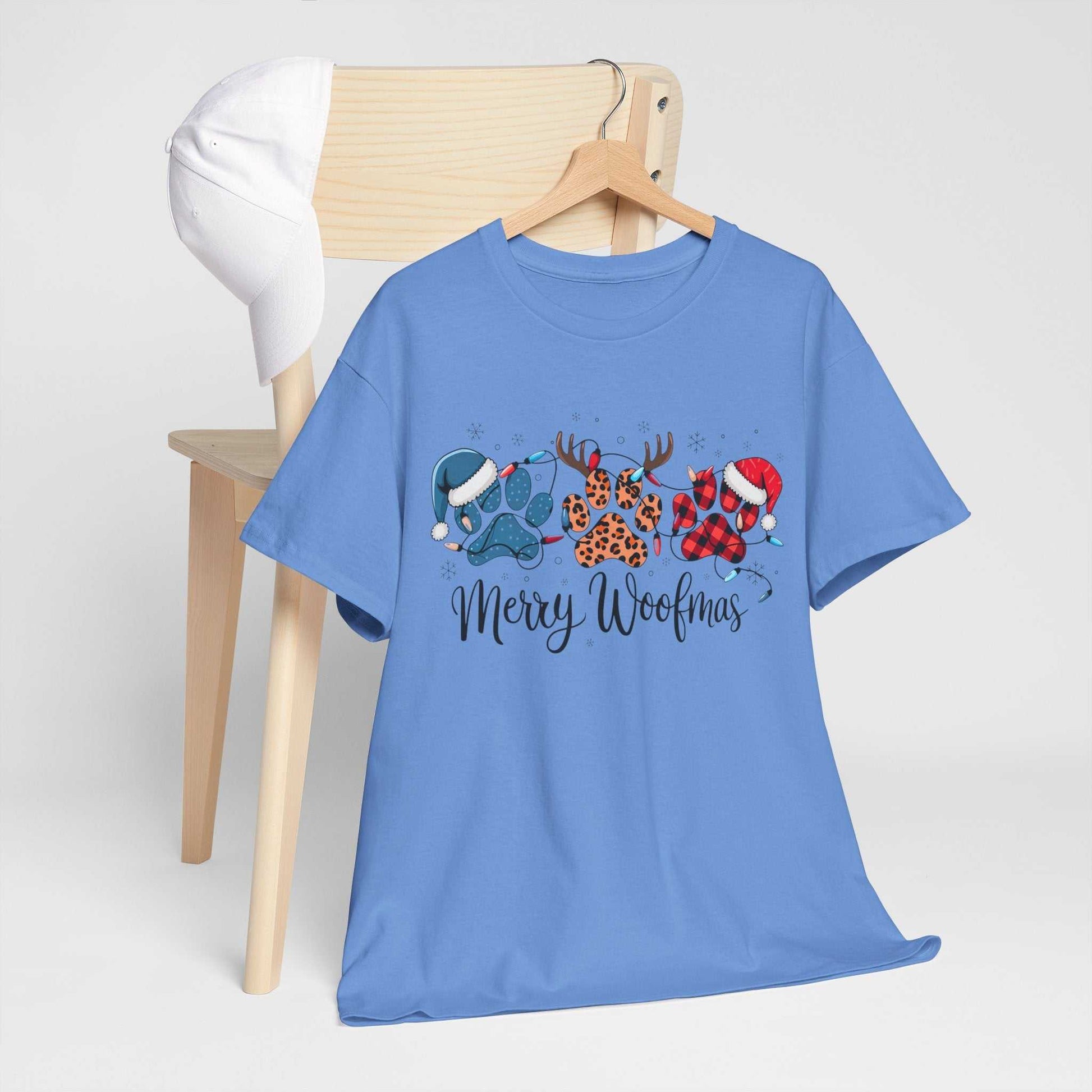 Blue Merry Woofmas Christmas tee with festive paw prints in buffalo plaid, leopard spots, Christmas lights, Santa hats, and antlers design