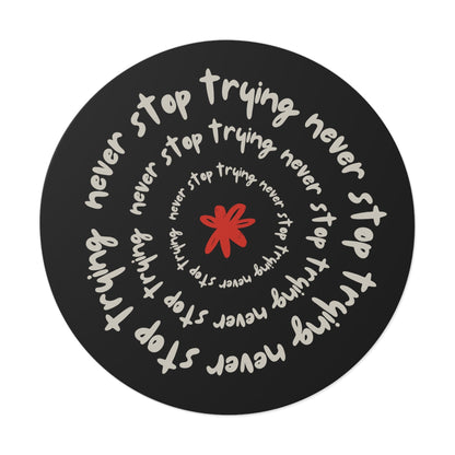 Don't Stop Trying round vinyl sticker with motivational spiral text and red star design on black background