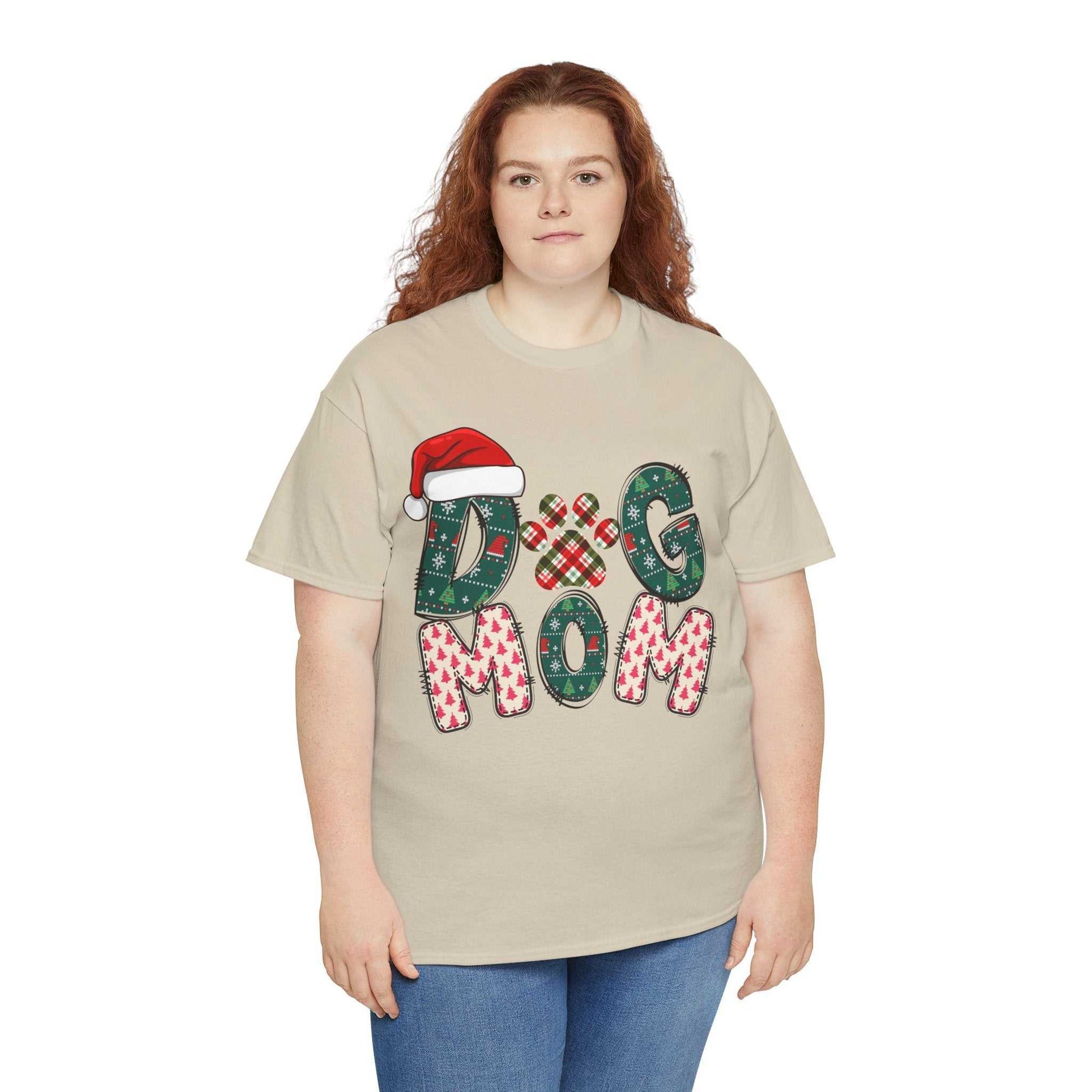 Unisex beige Christmas Dog Mom Tee with festive holiday design and Santa hat graphic, personalized option available.
