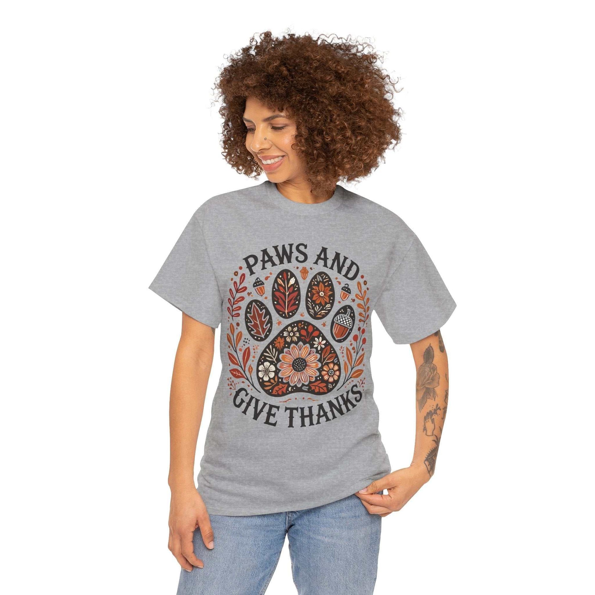 Woman wearing grey Paws and Give Thanks t-shirt with autumn-themed paw print design and fall leaves