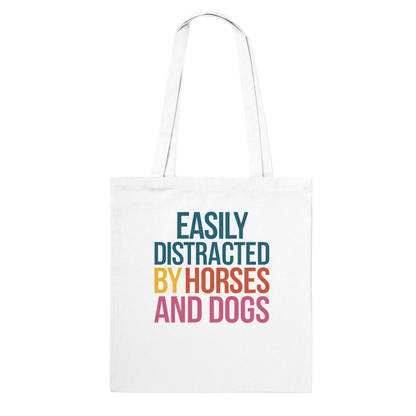 White cotton tote bag with Easily Distracted By Horses and Dogs colorful text design, long handles, eco-friendly and reinforced stitching