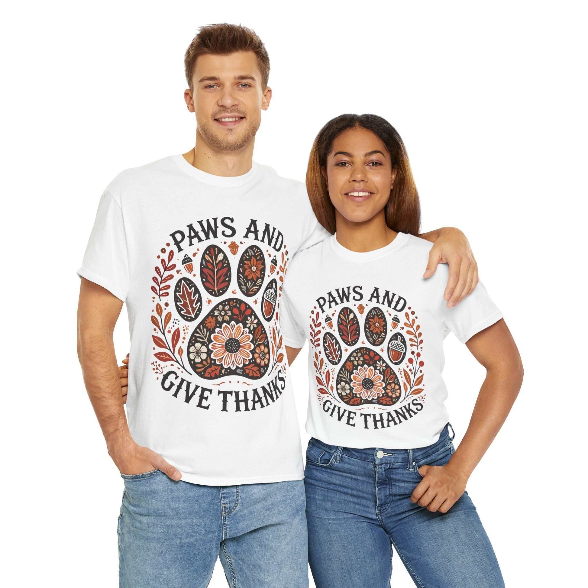 Couple wearing white "Paws and Give Thanks" tees with autumn leaf and paw print design