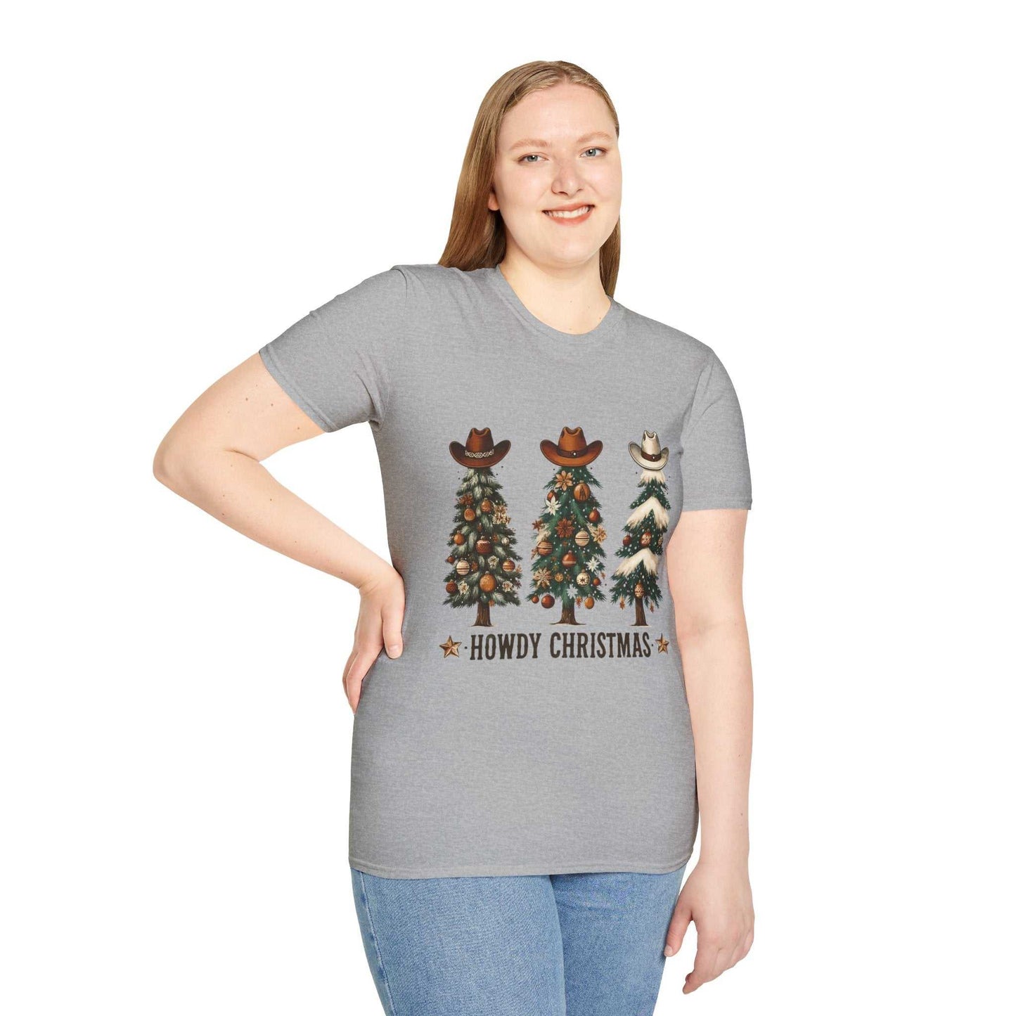 Woman wearing a grey Howdy Christmas Cowboy Tree T-Shirt with three decorated Christmas trees topped with cowboy hats and "Howdy Christmas" text.