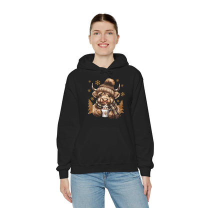 woman wearing black Highland cow hoodie with hot chocolate and winter design