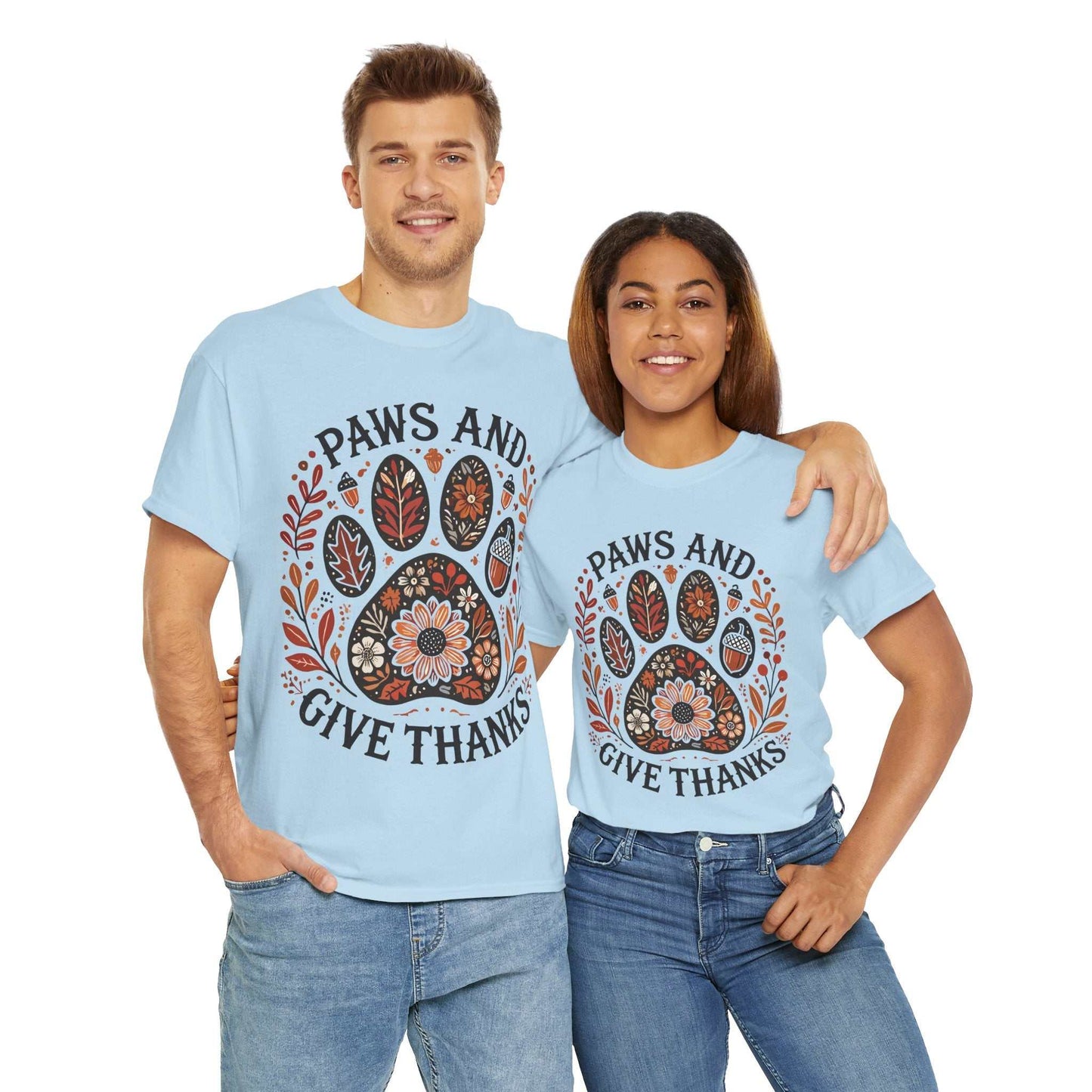 Couple wearing light blue "Paws and Give Thanks" t-shirts with autumn paw print design and fall foliage accents