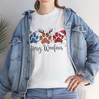Woman wearing white Merry Woofmas Christmas tee with paw prints in buffalo plaid, leopard spots, Christmas lights, and Santa hats under denim jacket
