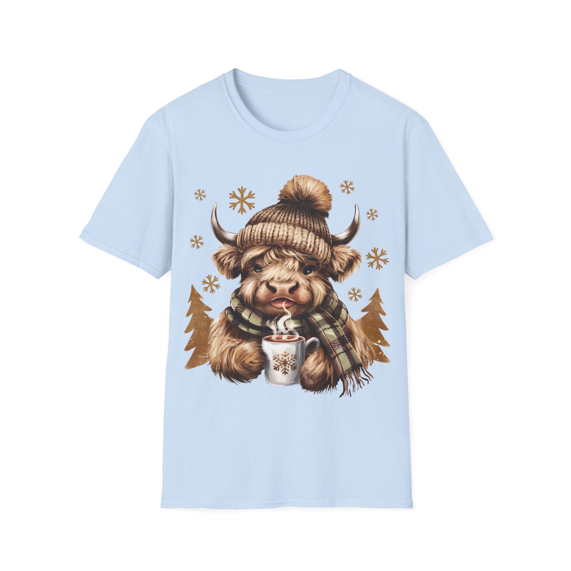Light blue t-shirt featuring a cozy Highland Cow wearing a knit hat and scarf, holding a hot chocolate cup with snowflakes.