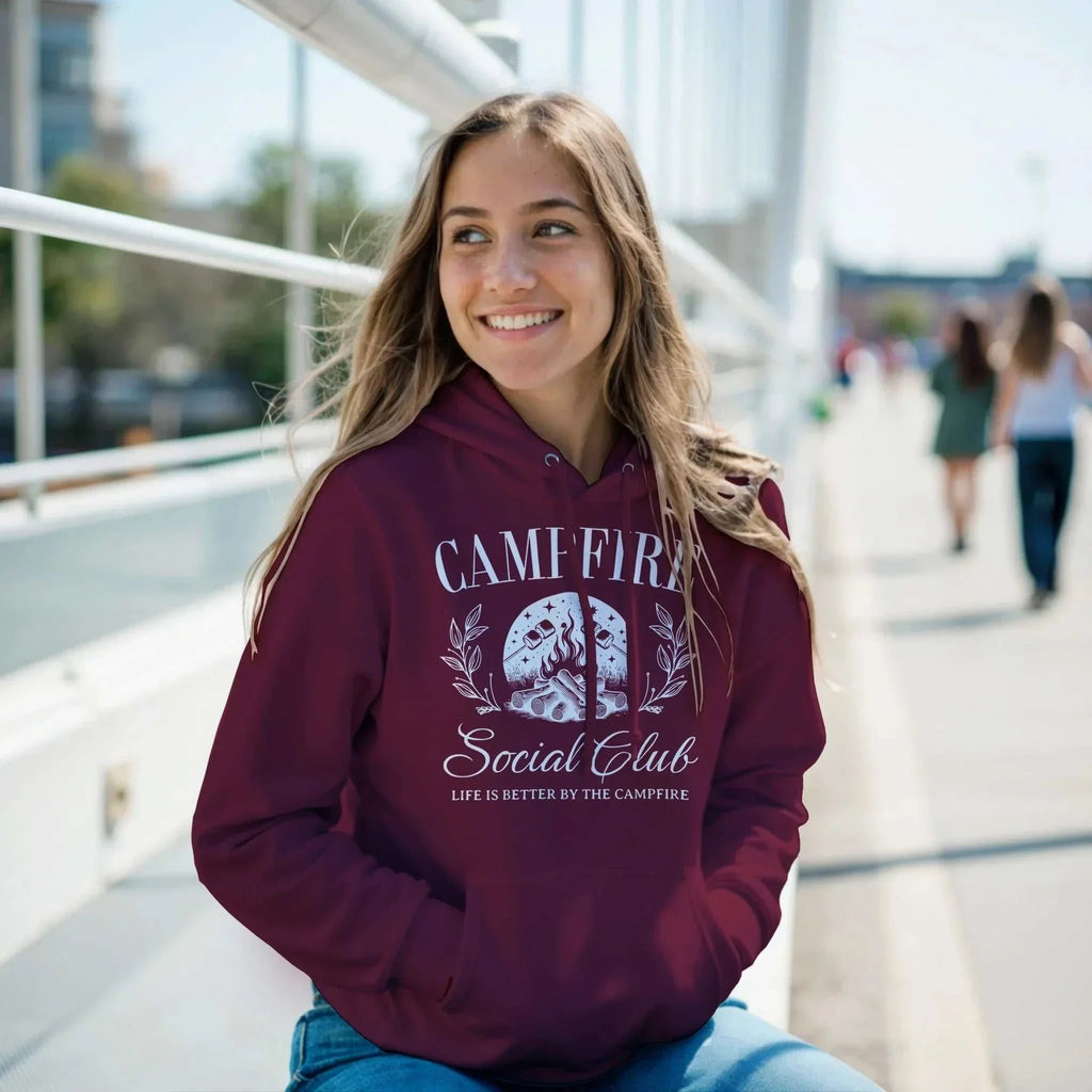Woman wearing a maroon Campfire Social Club Cozy Hoodie with front pouch pocket outdoors