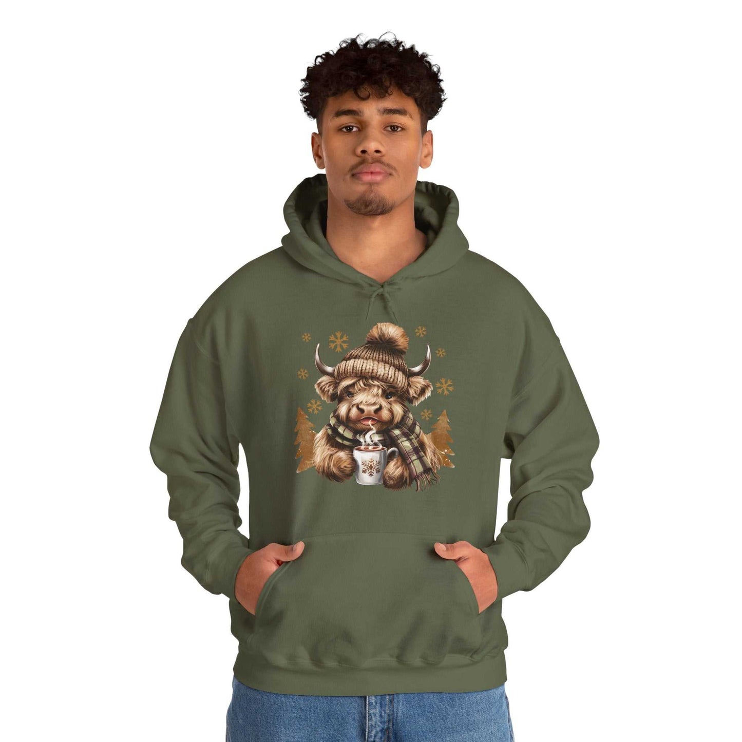 Man wearing olive green Highland Cow Hoodie with winter-themed cow holding hot chocolate illustration