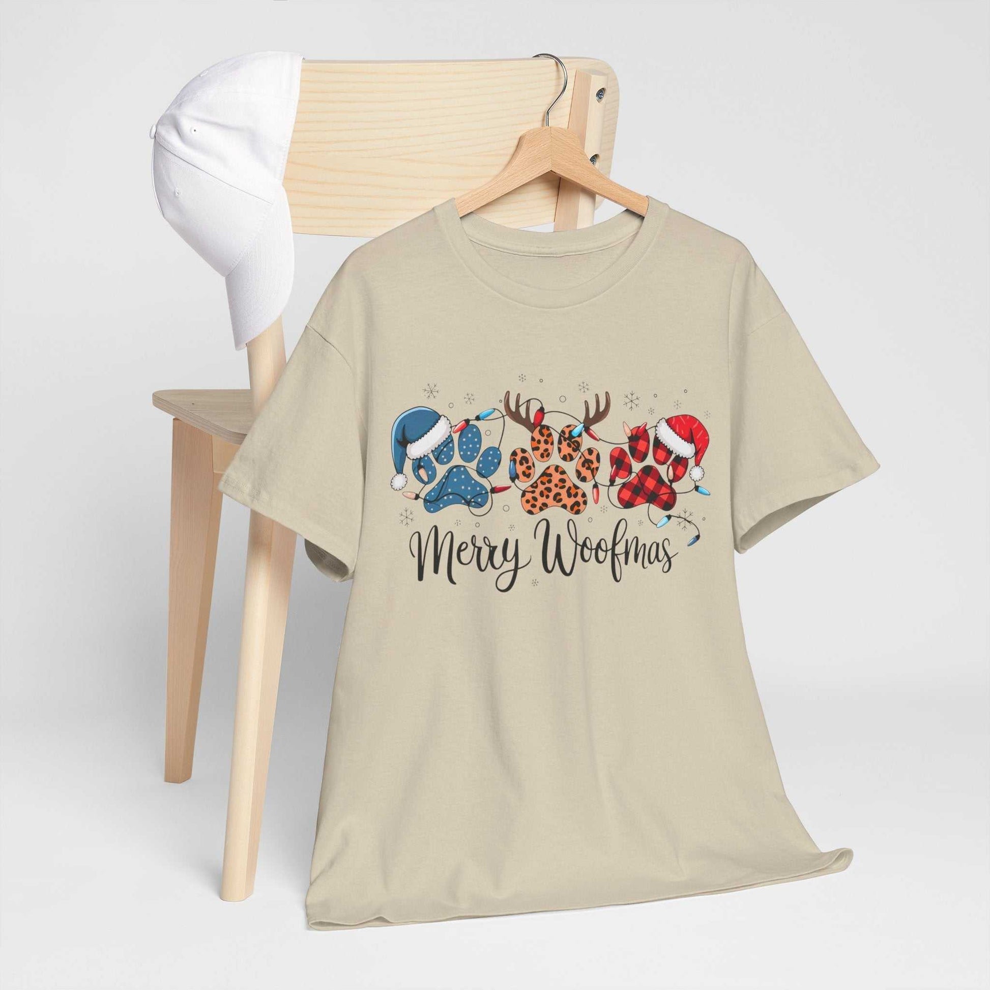 Beige "Merry Woofmas" Christmas tee with festive paw prints in buffalo plaid, leopard spots, and holiday hats
