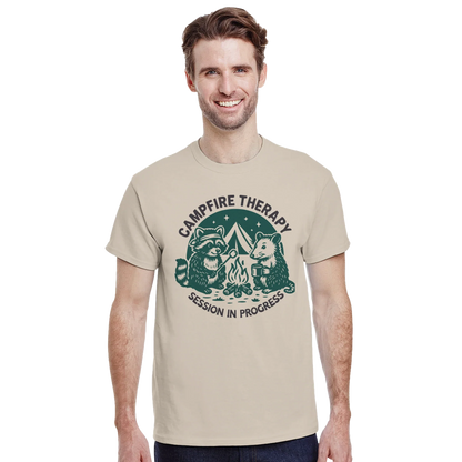 Man wearing Cute Campfire Therapy T-shirt with happy critter campers design around a campfire.