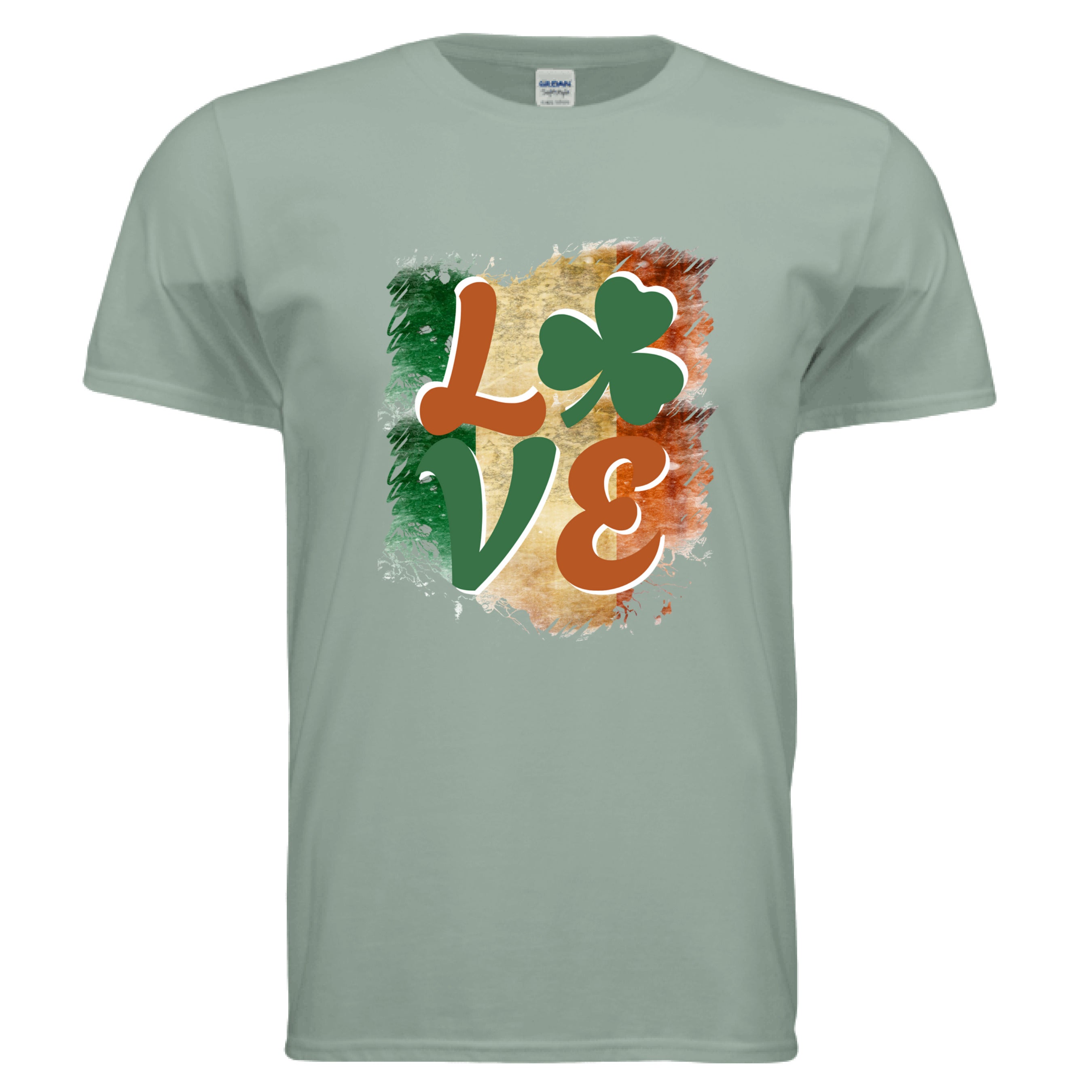 A sage green Celtic Love t-shirt featuring a vintage-style graphic of the word 'LOVE.' The letters 'L,' 'V,' and 'E' are in a stylized, earthy orange and green font. A vibrant green shamrock replaces the letter 'O.' The entire word is set against a distressed, brushstroke-style background representing the green, white, and orange vertical stripes of the Irish flag.