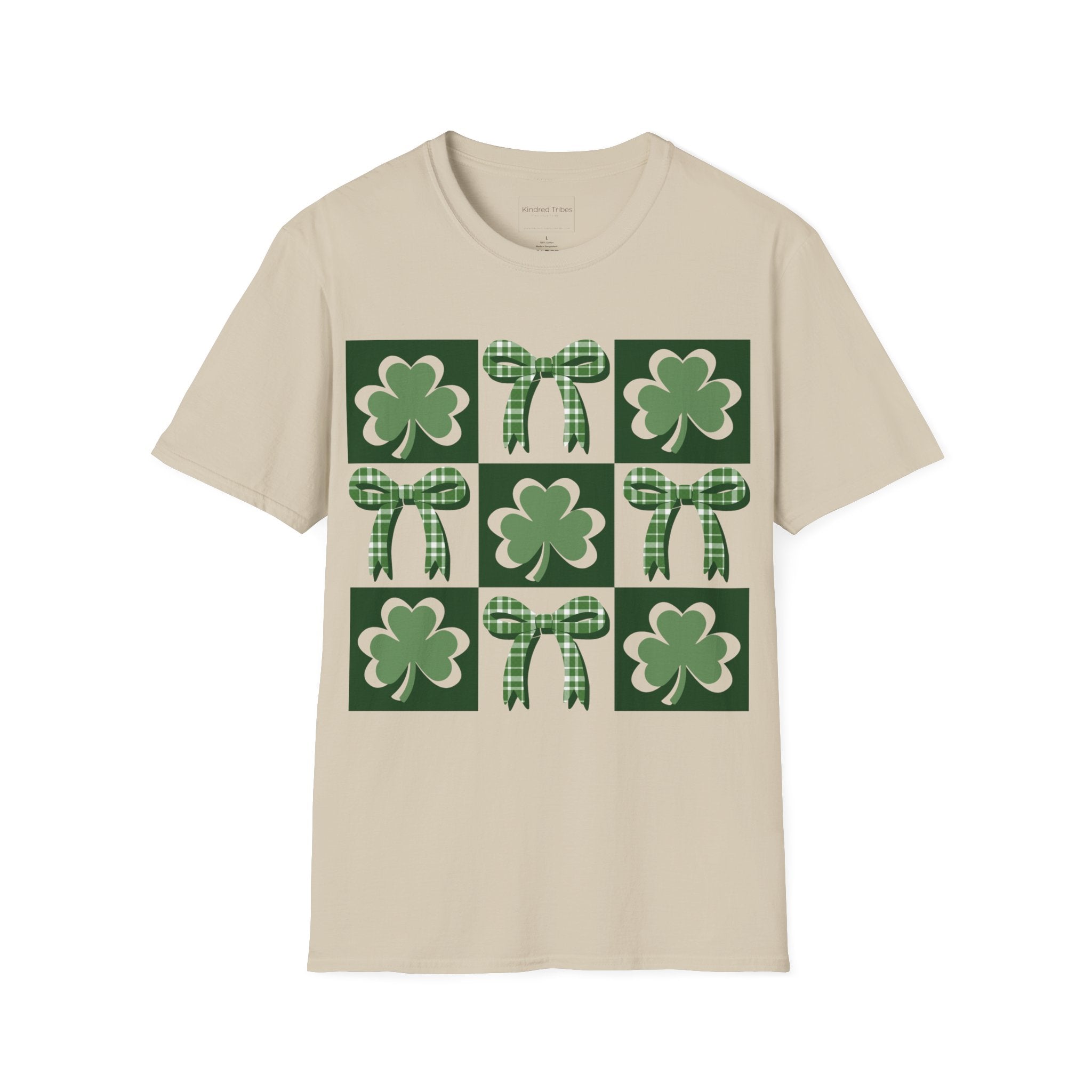 A Beige Lucky Coquette t-shirt featuring a 3x3 square grid graphic. The grid alternates between squares with a solid dark green background containing a green shamrock and squares containing a green-and-white checkered bow. The design is modern, symmetrical, and preppy in style