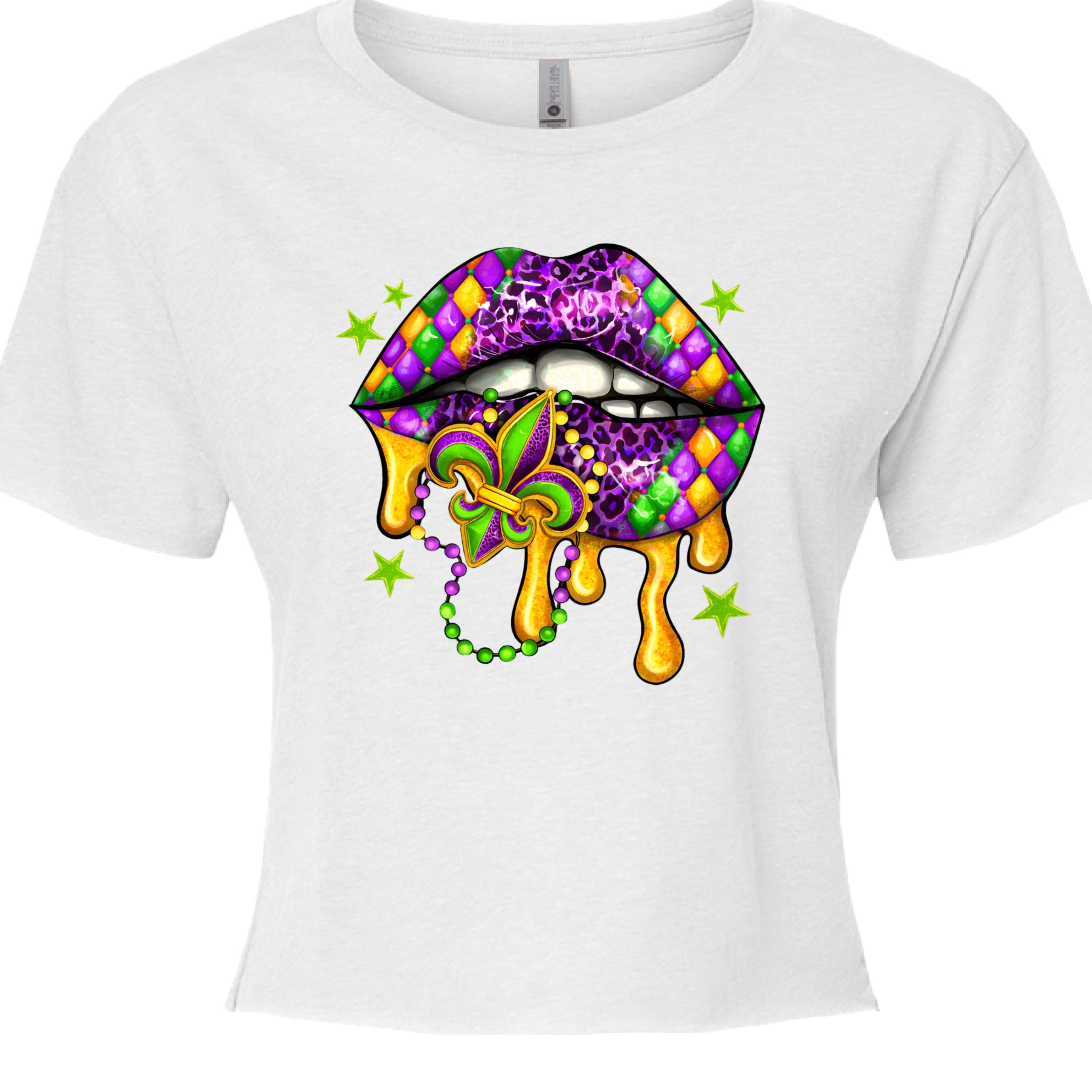 A white, cropped Mardi Gras Lips Baby Tee featuring a large, vibrant graphic of a pair of lips decorated in Mardi Gras themes. The top lip features a purple, gold, and green diamond harlequin pattern, while the bottom lip has a purple leopard print. Gold liquid "drips" from the mouth, which holds a decorative Fleur-de-lis and a string of Mardi Gras beads. 